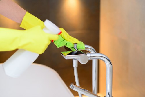 Carpet cleaning technician preparing equipment safely in a Colliers Wood property